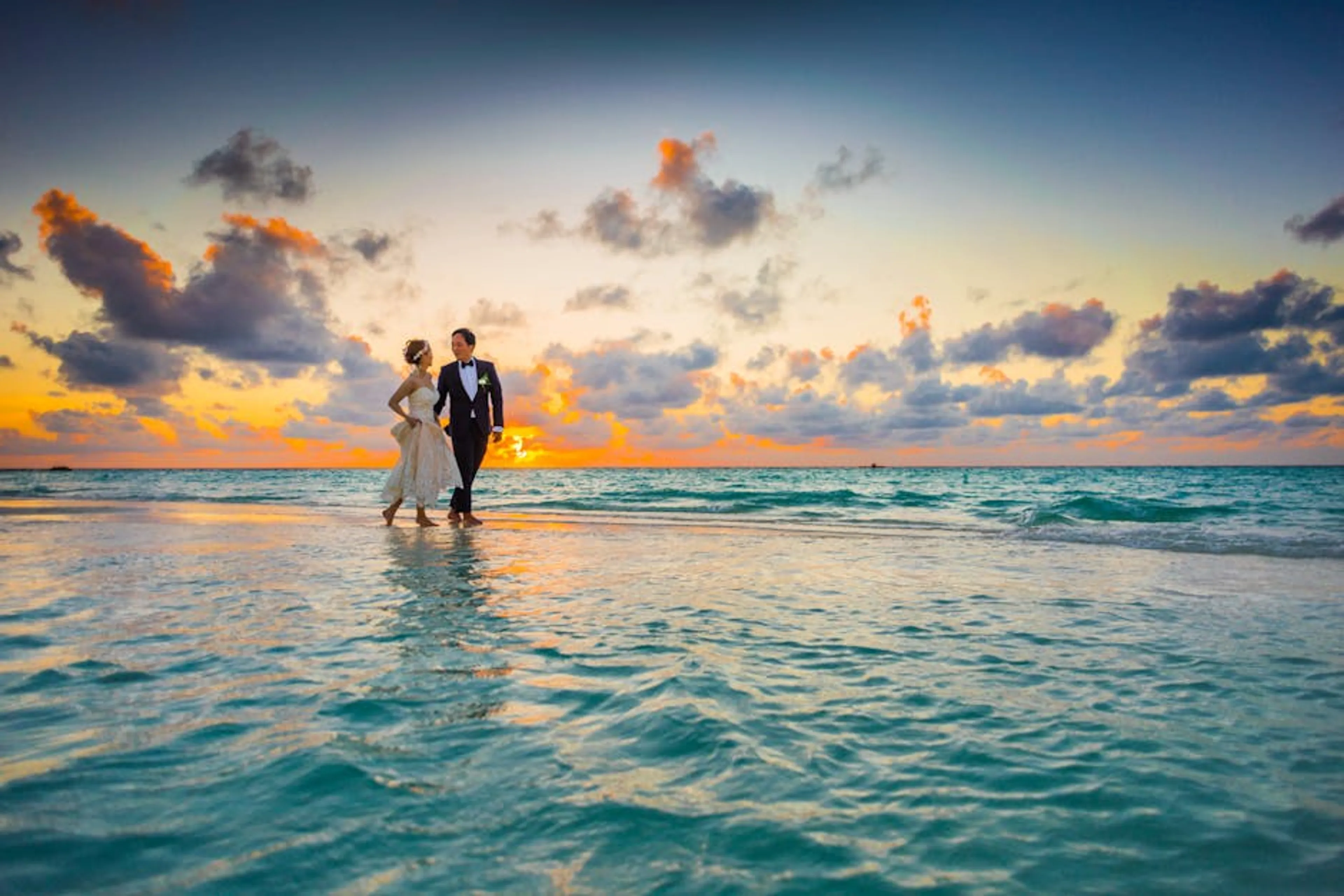 A young couple enjoying a romantic beach wedding during a vibrant sunset. Couple holding hands walking through a bustling city street on their honeymoon