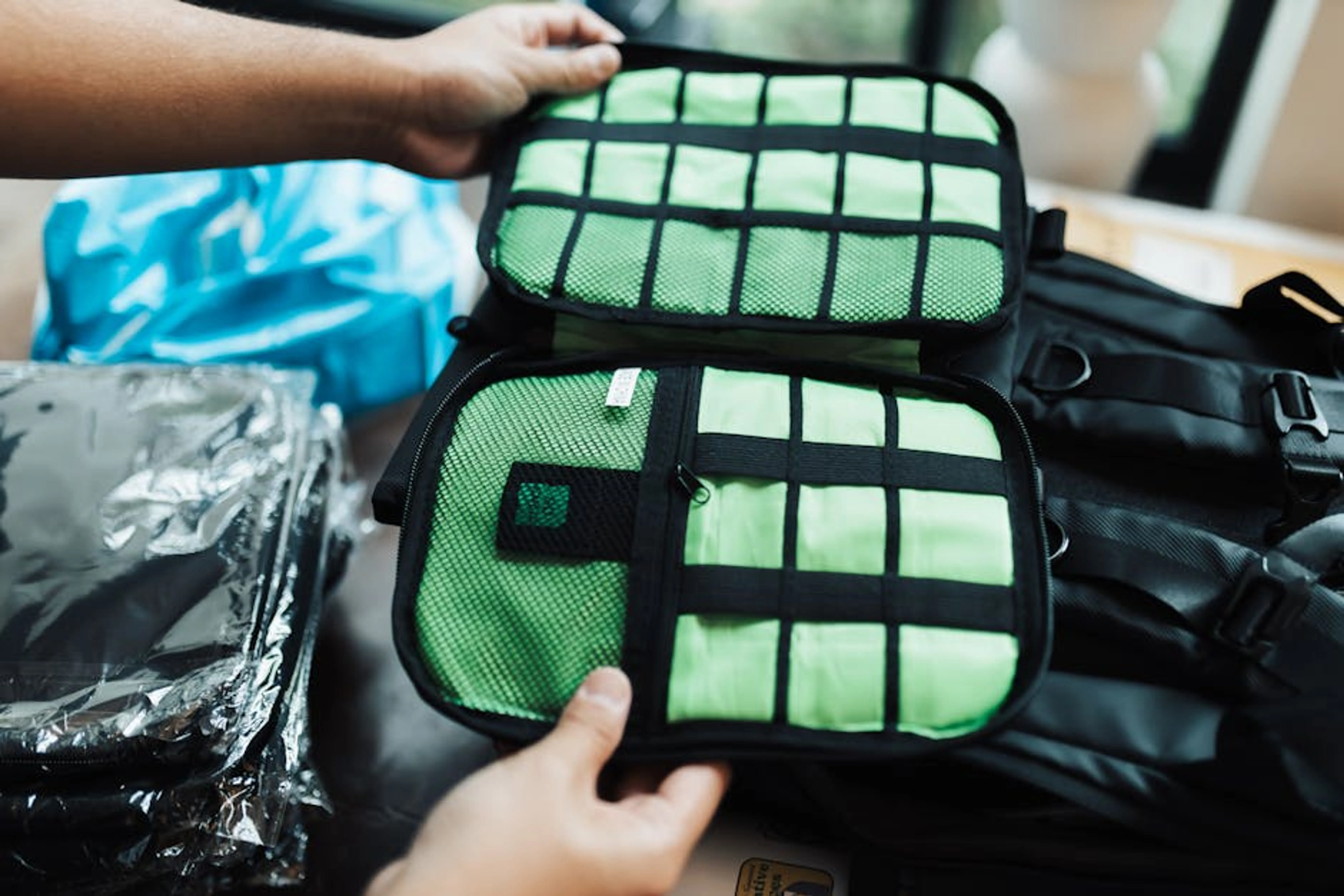 Close-up of hands organizing a travel luggage with packing cubes for efficient packing. Open luggage with neatly organized packing cubes containing various clothing items.