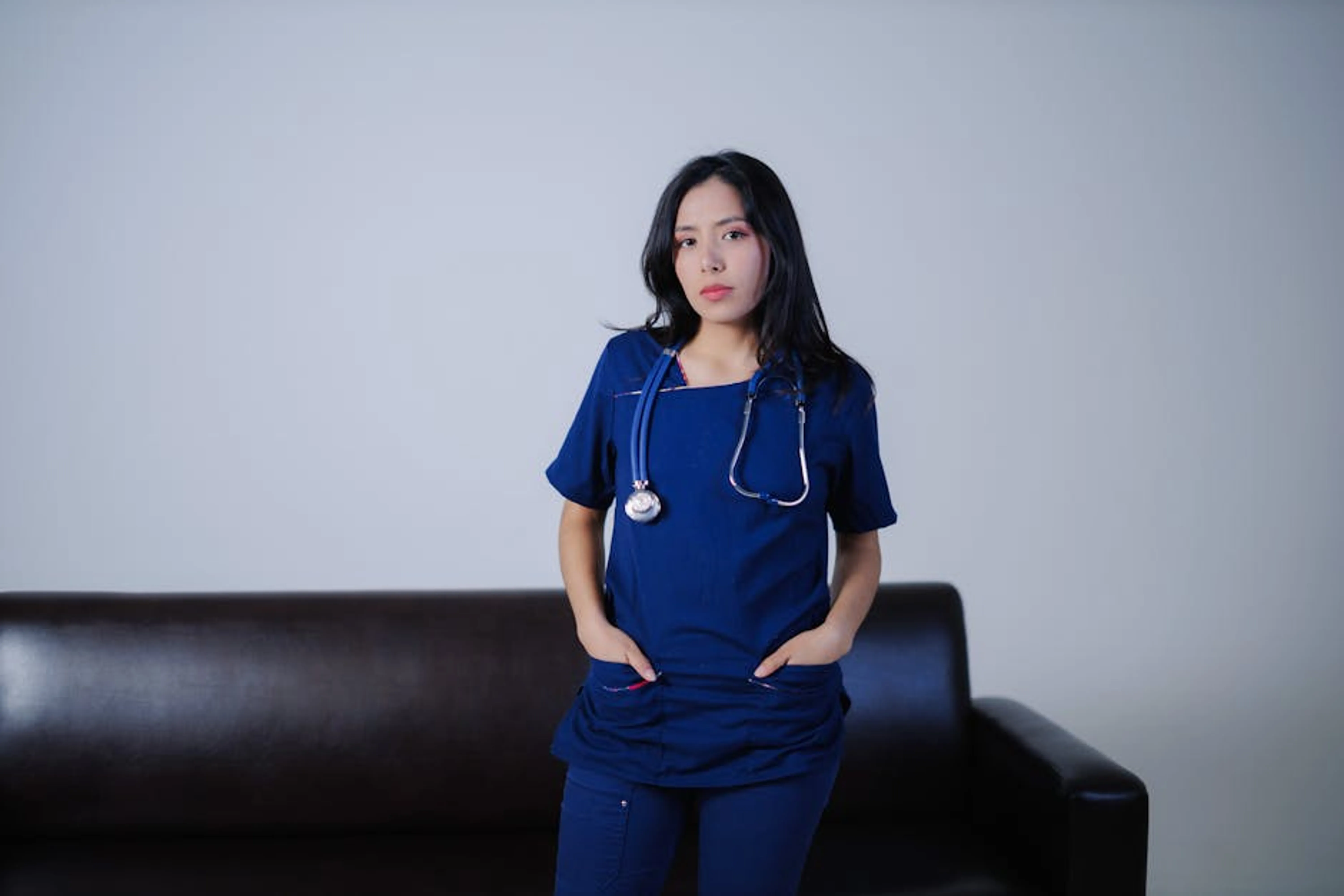 Young female nurse standing confidently indoors with stethoscope, showcasing professionalism and care. An image of a person contemplating a career choice, with nursing symbols in the background, representing the decision-making process.