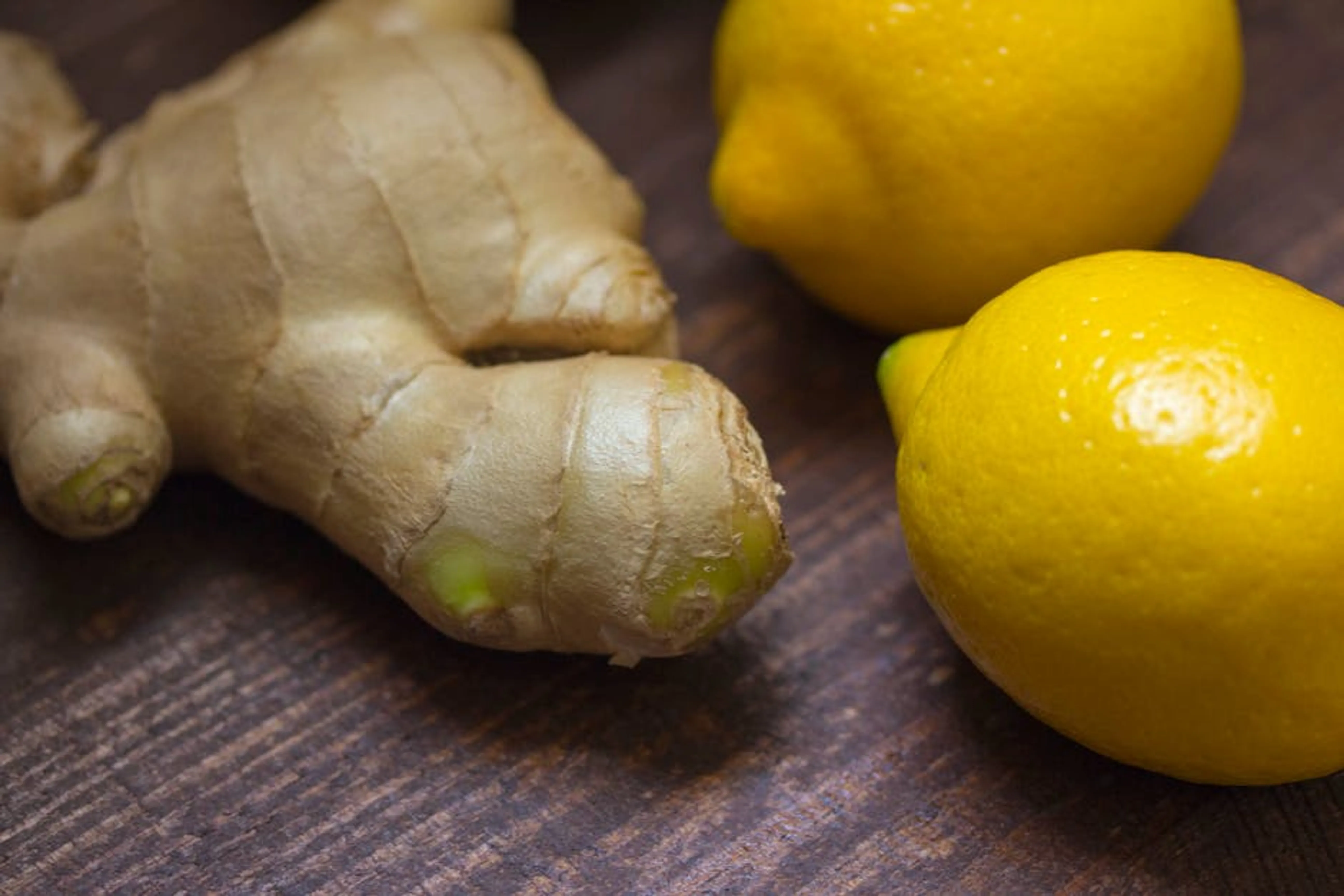 Close-up of fresh ginger root and lemons on a wooden surface showcasing natural ingredients. A minimalist, tidy living room with well-arranged furniture and a few decorative items, showcasing the benefits of an organized home.