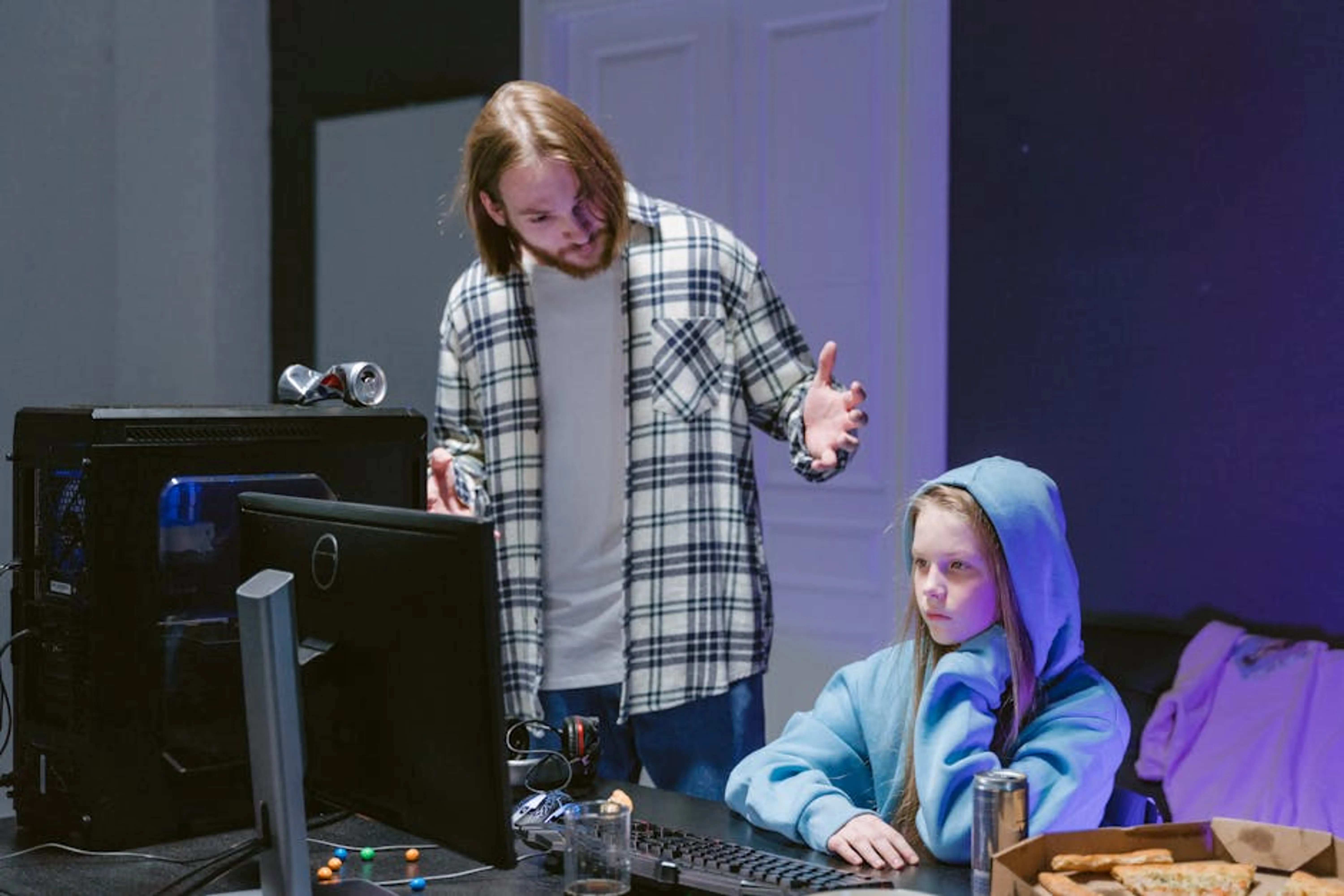 A father scolds his daughter playing video games on a computer, creating a tense moment. Parent holding a child's hand, symbolizing guidance and support through challenges